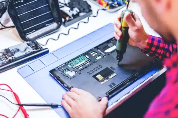 technik naprawiający laptopa